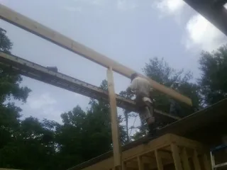 Carpenter setting a ridge beam over a new addition frame — Ice Dam Removal by Roofing Brothers in Craigsville