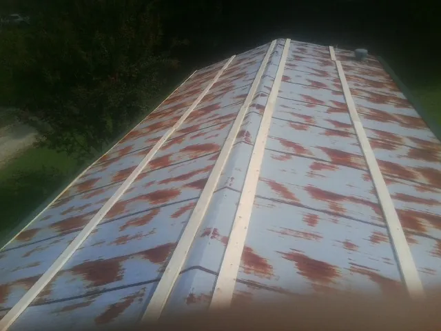 Rusted metal roof panels with new wood purlins before replacement — Storm Damage Roof Repair in Craigsville by Roofing Brothers